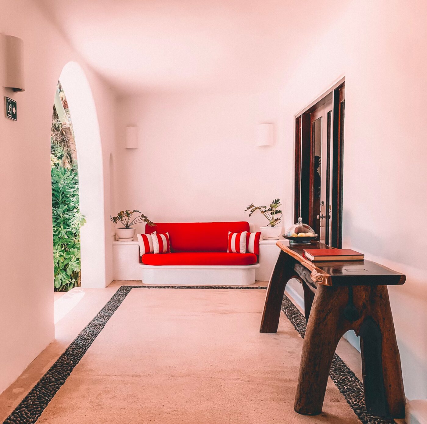 A hotel lobby with arched doorways and a red sofa